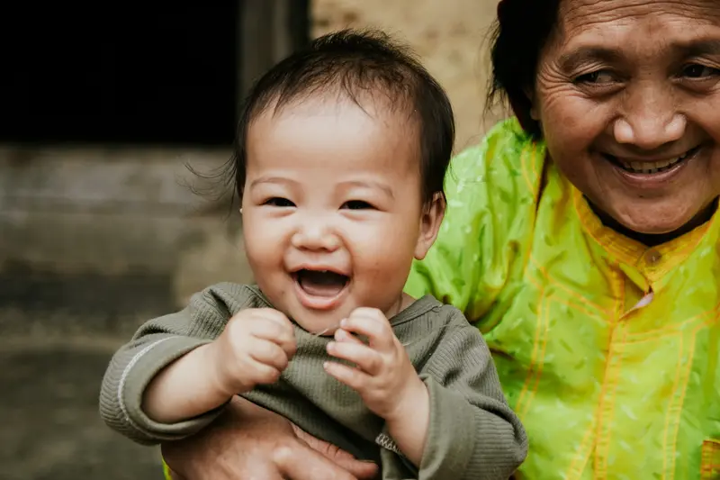 Bé cười tươi trên tay cô nhận giữ trẻ tại nhà TP.HCM sau những buổi đầu làm quen